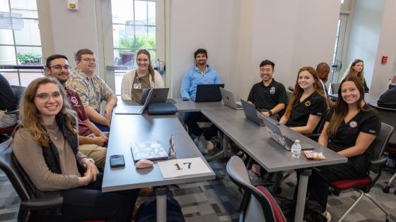 VCOM - Louisiana and ULM students sitting around a table smiling